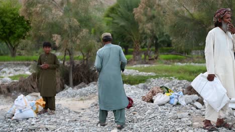 Pakistani-Male-Seen-Carrying-White-Tarp-Under-Arm-During-Flood-Drive-To-Provide-Aid