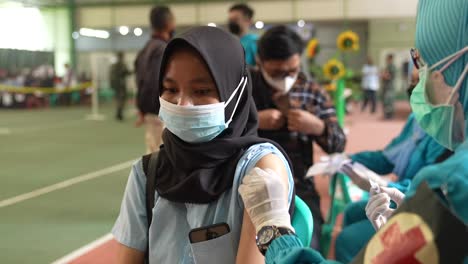 Medical-Nurse-in-Safety-Gloves-and-Protective-Mask-Making-Vaccine-Injections-for-Female-Patient-at-vaccination-rush