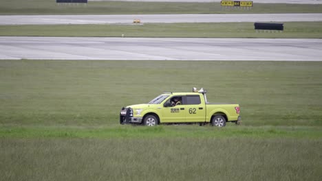 Male-Staff-Member-Driving-at-Airport-in-Yellow-Truck