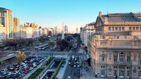 Drone-view-of-Teatro-Colón-with-rush-hour-traffic-on-9-de-Julio-Avenue-at-sunset
