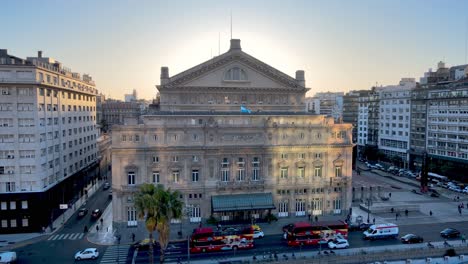 City-Sightseeing-buses-pass-in-front-of-grand-Colon-Theatre,-Buenos-Aires