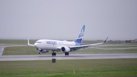 A-Westjet-Passenger-Airplane-Touching-Down-on-a-Wet-Runway