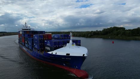 Drone-orbiting-around-BG-Onyx,-a-freight-line-container-ship-sailing-across-Oude-Maas-in-Zwijndrecht-of-the-Netherlands