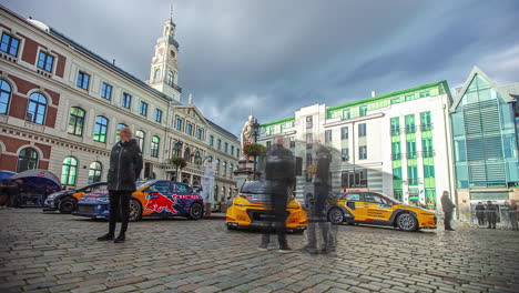 Static-shot-of-racing-cars-parked-in-front-of-a-fountain-during-RX-World-Rally-Cross-Championship-held-in-Riga,-Latvia-on-a-cloudy-day