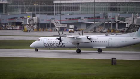 An-Air-Canada-Express-Dash-8-Taxiing-at-Vancouver-Airport,-Rainy-Day