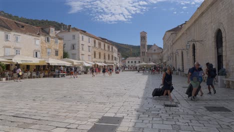 Slow-mo-wide-angle-view-of-travelers-in-the-main-square-in-Hvar,-Croatia