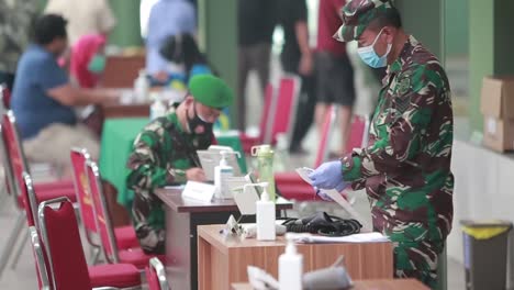 Two-Indonesian-National-Army-doctors-are-writing-or-registering-patients-at-the-registration-desk-in-front-of-the-hospital