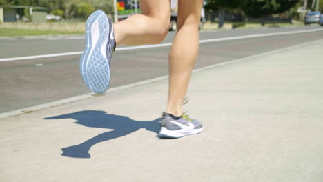 Close-Up-Female-Athlete-Legs-With-Sneakers-Jogging-Along-Suburban-Footpath,-4K