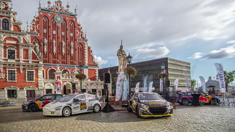Shot-of-race-cars-from-RX-World-Race-Cross-Championship-are-on-display-on-a-cloudy-day-in-timelapse-in-front-of-an-old-historic-structure