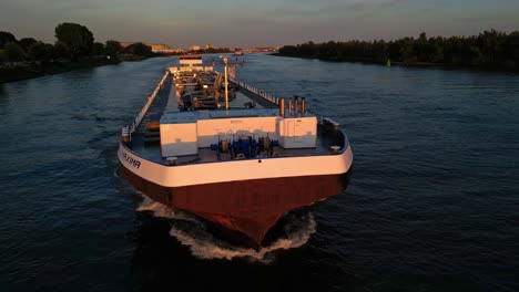 Aerial-Parallax-Shot-Around-Forward-Bow-Of-Maxima-Liquid-Cargo-Ship-Bathed-In-Sunset-Light