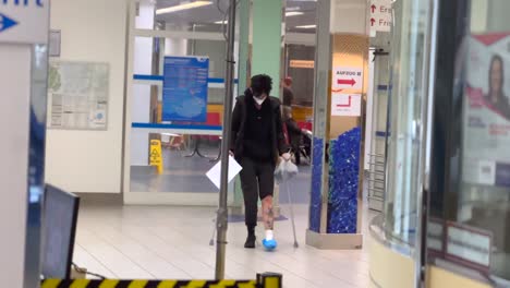 Woman-with-crutches,-gibs-and-mask-in-hospital