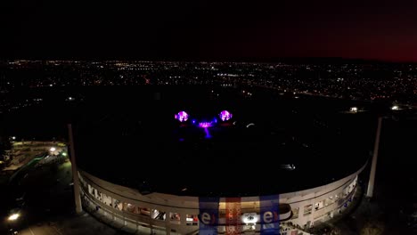 Aerial-orbiting-during-Coldplay-concert-at-dusk-lights,-Beautiful-scenery,-Santiago-cityscape