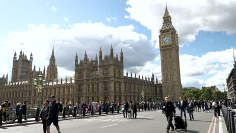 Static-shot-of-people-walking-across-the-Palace-of-Westminster,-houses-of-the-Parliament-of-the-United-Kingdom,-London