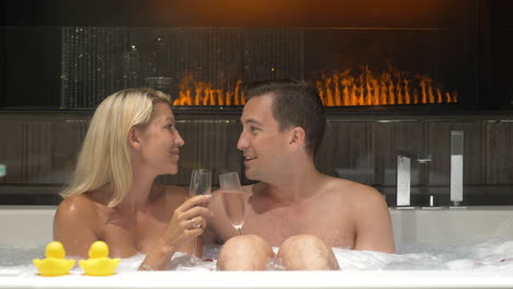 Glückliches-Junges-Paar,-Das-Weißwein-Trinkt,-Während-Es-Spricht-Und-Sich-Im-Whirlpool-Entspannt
