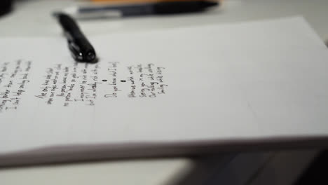 A-Black-Fountain-Pen-Laid-On-Top-Of-White-Paper-Board-With-Unfinished-Love-Poem