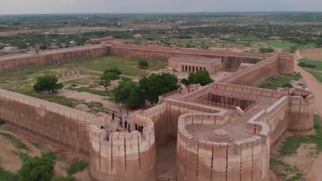 Drone-move-backward-takes-an-wide-angle-shot-of-the-Umerkot-Fort-with-its-surrounding-area-in-Sindh,-Pakistan