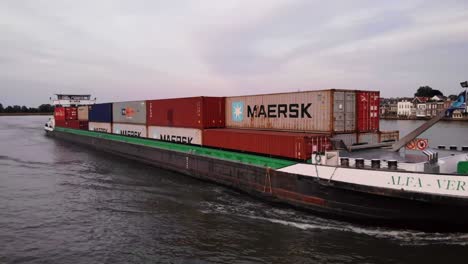 Full-Container-Ship-drives-through-River-in-Dordrecht,-The-Netherlands
