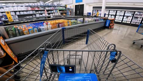 POV-while-pushing-a-cart-through-Walmart-past-the-dairy-refrigerated-storage