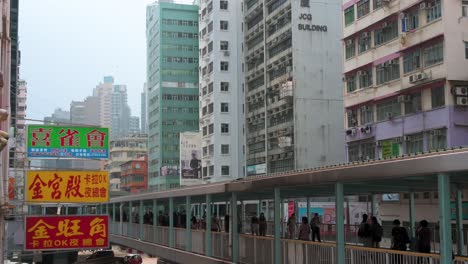 Peatones-Y-Viajeros-Chinos-Caminan-Sobre-Un-Puente-Elevado-En-El-Distrito-De-Kowloon-De-Hong-Kong