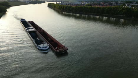Aerial-View-Over-Amoureus-Push-Freighter-Sailing-Along-Beneden-Merwede-During-Sunset