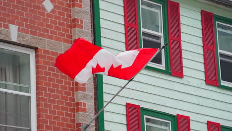 Bandera-Canadiense-Ondeando-En-El-Viento-En-El-Exterior-De-Un-Edificio