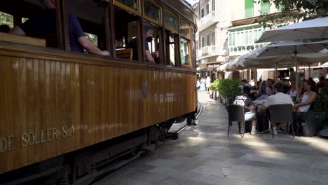The-famous-orange-tram-on-the-streets-of-Port-de-Soller,-Spain