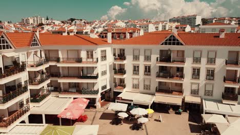 Dronie-Shot,-Pull-Back-From-Complex-Unveiling-Beautiful-Cityscape-Of-Ericeira,-Portugal
