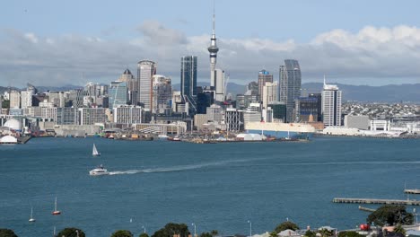 Die-Skyline-Von-Auckland-In-Warmem-Sonnenschein-Mit-Segelbooten-Und-Fähren,-Die-Die-Gewässer-Von-Westhaven-überqueren