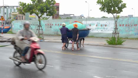 Menschen,-Die-Ein-Kleines-Boot-Auf-Der-Straße-Auf-Eine-Höhere-Ebene-Nehmen,-Vermeiden-Große-Wellen-Des-Tropischen-Sturms,-Da-Nang-Stadt-Vietnam-Vor-Dem-Noru-taifun