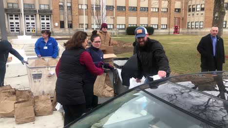 Michigan-Governor-Gretchen-Whitmer-handing-out-food-during-Covid-19-pandemic-in-Lansing,-Michigan-at-a-school