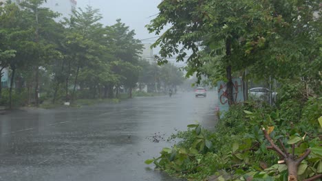 Heavy-Rainfall-and-Wet-Road-Before-Incoming-Tropical-Typhoon,-Car-and-Motorbike-Driver-on-Street-of-Da-Nang,-Vietnam
