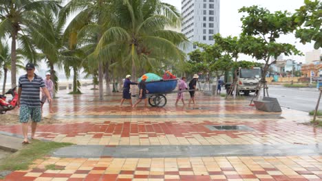 Menschen,-Die-Ein-Kleines-Boot-Von-Der-Meeresküste-Auf-Der-Küstenstraße-Vor-Dem-Tropischen-Taifun,-Da-Nang-City,-Vietnam,-Verlegen