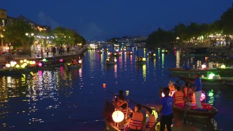 Tourist-boat-rides-on-river-illuminated-by-colorful-lanterns,-Hoi-An-old-town