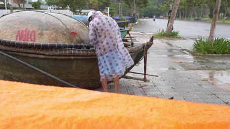 Man-Securing-His-Boat-by-the-Road-Off-the-Sea-Coast-Before-Storm-Hits-Mainland,-Da-Nang-City,-Vietnam