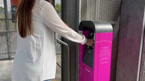 Female-passenger-touching-off-at-the-ticketing-machine-at-Bowen-Hills-train-station,-using-go-card-to-pay-for-the-trip,-Brisbane-Queensland,-Australia
