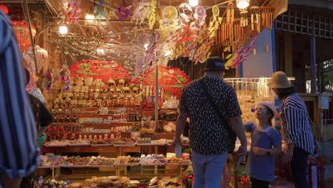Viajeros-Comprando-Recuerdos-En-El-Mercado-Nocturno-De-Hoi-An,-Vietnam