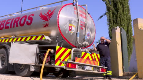 footage-of-a-firefighter-and-the-fire-truck-coming-to-replenish-a-house's-dried-up-water-supply-during-the-global-warming-drought