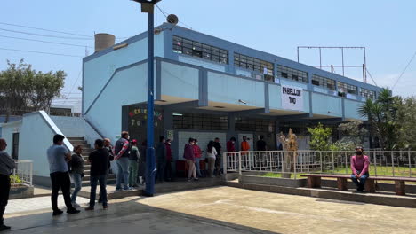 Peruvian-voters-patiently-waiting-in-line-at-polling-station-during-municipal-elections-on-calm-sunny-day-at-La-Molina,-Lima,-Peru