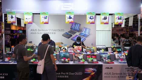Chinesische-Einzelhandelskunden-Werden-Am-Asus-Markenstand-Gesehen,-Der-Laptops-Verkauft,-Während-Besucher-In-Hongkong-Elektronische-Produkte-Wie-Festplatten,-Fernseher-Und-Computer-Zu-Reduzierten-Preisen-Durchsuchen-Und-Kaufen