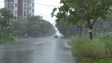 Stormy-Torrential-Rain,-Strong-Wind-and-Incoming-Typhoon-Scene,-People-Riding-Motorbikes-on-Wet-Road-in-Da-Nang-City,-Vietnam