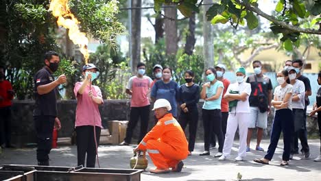 Yogyakarta,-Indonesia---24-De-Septiembre-De-2022:-Mujer-Joven-Asiática-Practicando-Cómo-Extinguir-Un-Incendio-En-Una-Fuga-De-Estufa-De-Gas-En-El-Patio