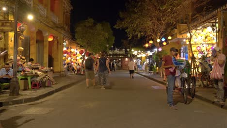 Tourists-strolling-through-ancient-Old-Town-of-Hoi-An-at-night,-Vietnam