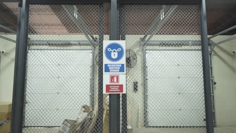Empty-warehouse-gates-with-some-boxes-and-a-no-trespassing-sign