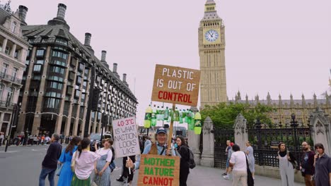 Viejo-Activista-Climático-Masculino-En-Westminster,-Londres,-Sosteniendo-El-Cambio-Climático-Y-Carteles-Antiplásticos-Para-Protestar-Contra-La-Contaminación-Por-Co2-Y-La-Crisis-Climática-Y-Por-La-Protección-Y-Preservación-De-La-Naturaleza