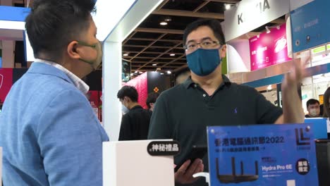 A-Chinese-tech-buyer-visits-the-American-brand-of-data-networking-hardware-company,-Linksys,-booth-offering-numerous-WIFI-routers-during-a-Computer-and-Communications-Festival-in-Hong-Kong