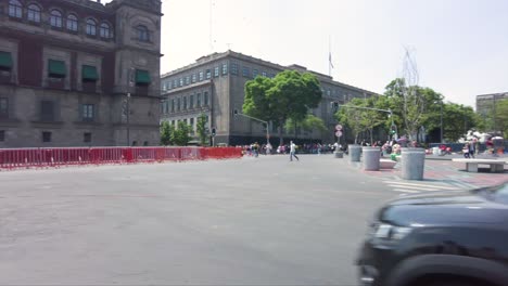 Panoramablick-Auf-Den-Regierungspalast-In-Mexiko-Stadt-Mit-Menschen-Und-Autos,-Die-An-Einem-Sonnigen-Tag-Vorbeifahren