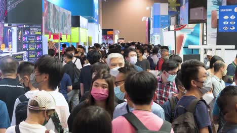 Tilt-shot-of-large-crowds-of-Chinese-buyers-browsing-and-walking-through-the-hallways-to-purchase-discounted-electronic-products,-such-as-hard-drives,-TVs,-and-laptops,-at-a-computer-festival