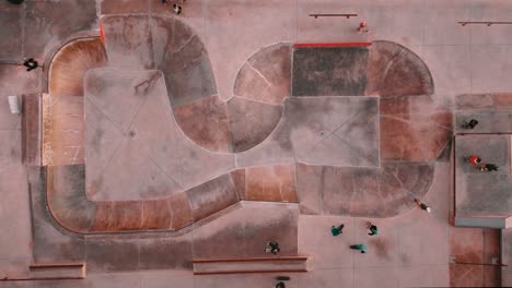 Overhead-Shot-Of-Board-Riders-Wearing-Helmets-In-Ericeira-Skate-Park,-Special-Ground-Design,-Portugal
