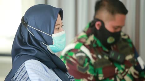 Eine-ältere-Frau-Mit-Maske-Sitzt-In-Einem-Krankenhaus-In-Der-Schlange,-Um-Während-Einer-Pandemie-In-Indonesien-Eine-Virusimpfung-Zu-Erhalten