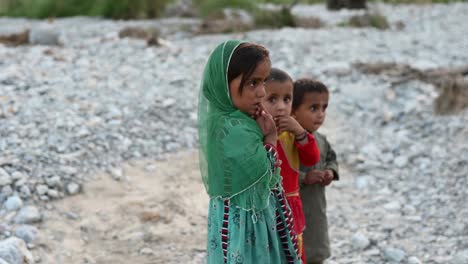 Young-Children-Looking-And-Walking-Across-Dry-River-Bed-In-Balochistan